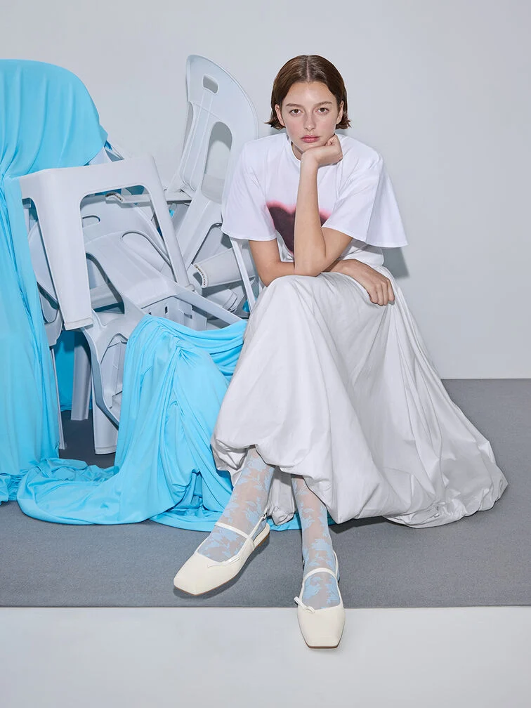 Mary Jane flats styled with socks, a T-shirt and a skirt.